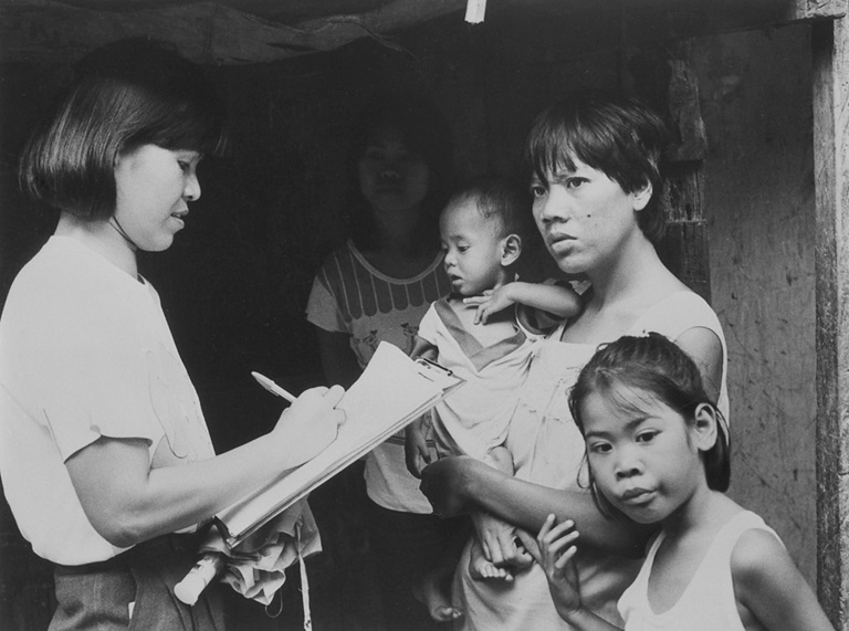 A barangay health worker conducts house-to-house visit and offers health advice to mothers.